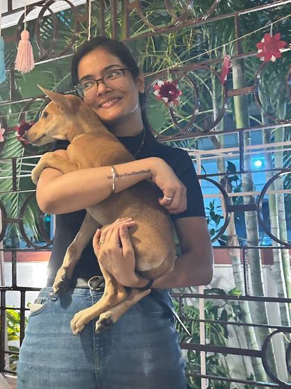 A participant smiles as she hugs a happy indie pup during our art event in Kolkata.