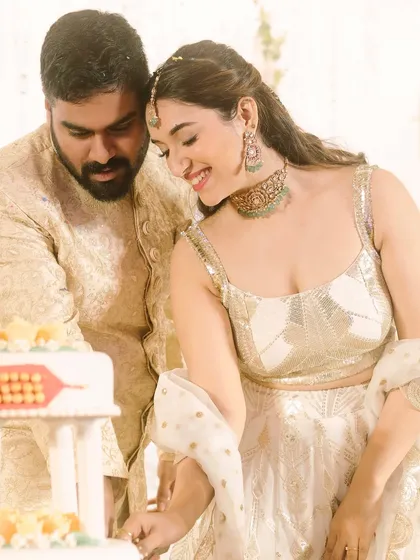 A sweet moment during the cake cutting. The bride's elegant makeup and high ponytail hairstyle look chic and sophisticated.