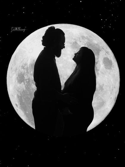 A romantic silhouette of a couple against the full moon. Their loving gaze and close embrace create a beautiful and timeless image of their connection.