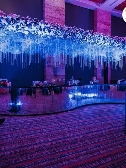 A custom-designed bar for the celestial-themed Sangeet, with a mirrored surface and a dramatic overhead installation of flowers and hanging crystals.