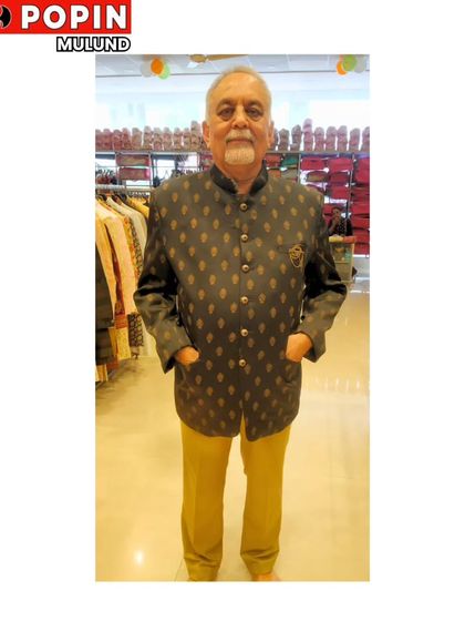 A client looking distinguished in a dark, subtly patterned Jodhpuri suit. This is a timeless and elegant choice for men of all ages.