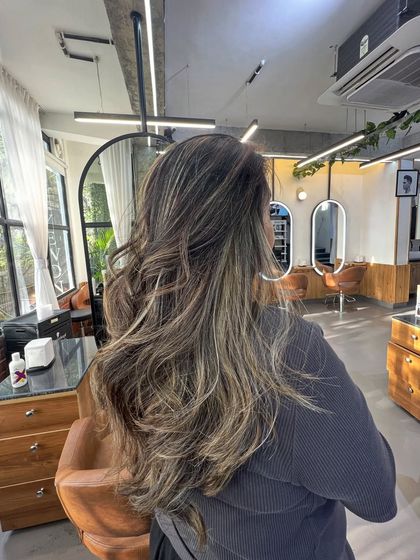 A side view of this multi-tonal brunette look, highlighting the layers and waves that give the style so much body.