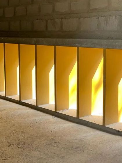 A detail of the gallery's lower window openings during construction. The play of light and shadow through these repeating forms is an intentional design element, visible even at this early stage.