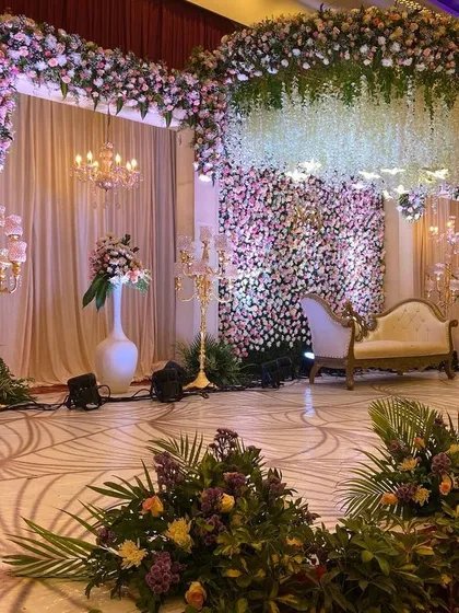 A vision in pastel pink, this reception stage is all about soft, romantic elegance. We combined dense walls of roses and chrysanthemums with a cascading floral ceiling and crystal chandeliers to create a truly breathtaking floral fantasy.