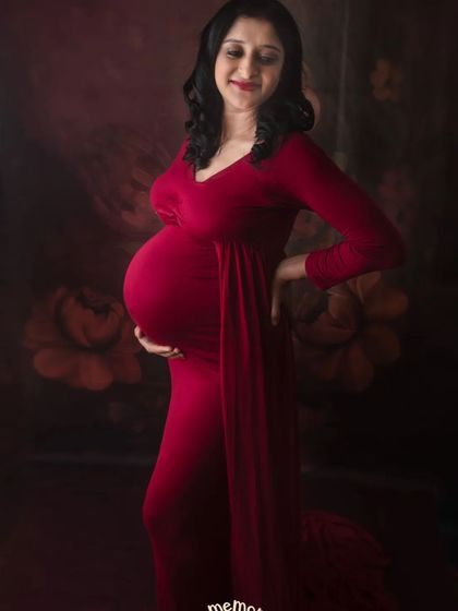 A side profile is a wonderful way to showcase the baby bump. This mom-to-be looks so serene and beautiful in this deep red dress, lost in a happy thought.
