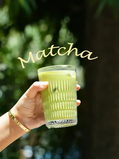 An outdoor shot of an iced matcha latte. Using natural light and a green background gives the photo a fresh, healthy, and organic feel.