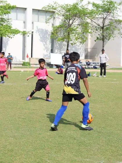 A player controls the ball under pressure from an opponent. Our training focuses on developing composure and technical skill in real-game situations.