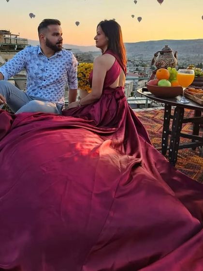 Another angle of the couple's rooftop shoot, showing the beautiful spread of the magenta gown and the breakfast setup.