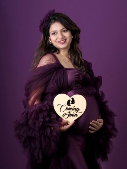 Announcing that someone special is "Coming Soon." This mom-to-be looks radiant in a wine-colored gown with a dramatic ruffled tulle robe, adding layers and texture to her studio shoot.