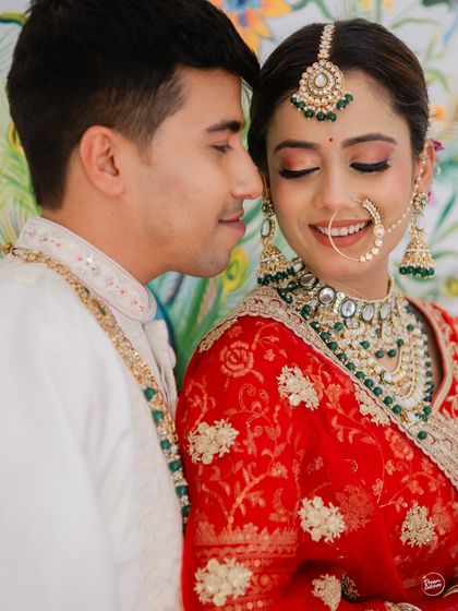 A moment of shared happiness and affection. The bride's joyful smile and the groom's gentle expression tell a story of love and comfort during their beautiful Udaipur wedding.
