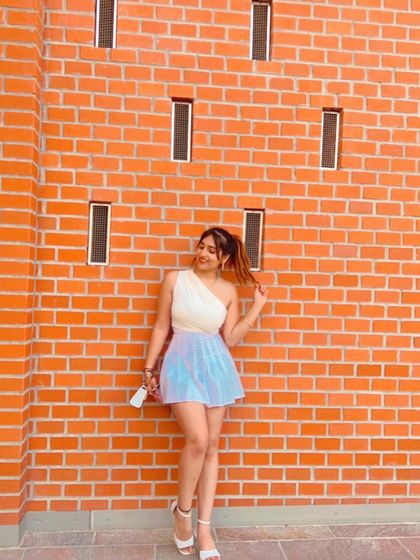 A cute and colorful outfit against a brick wall in Europe. This shows my fun and playful travel fashion.