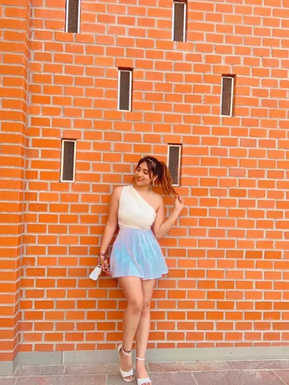 A cute and colorful outfit against a brick wall in Europe. This shows my fun and playful travel fashion.