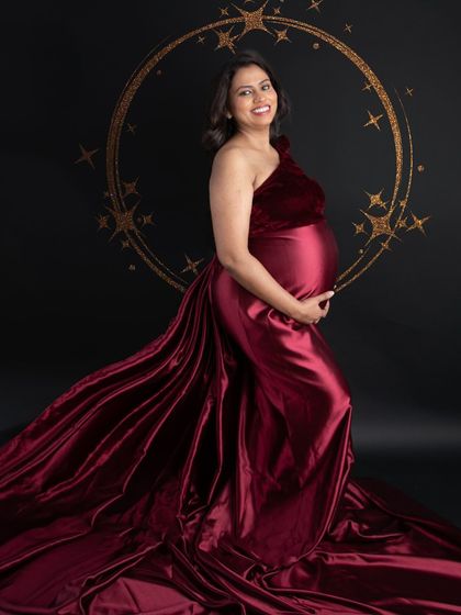 A classic maternity portrait with a touch of sparkle. The golden halo effect adds a magical glow to this elegant shot of the mom-to-be in a flowing red gown.