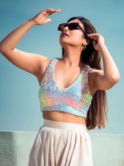A sunny, outdoor shot perfect for a summer collection lookbook. The sequined top catches the light beautifully, and the pose feels natural and aspirational.