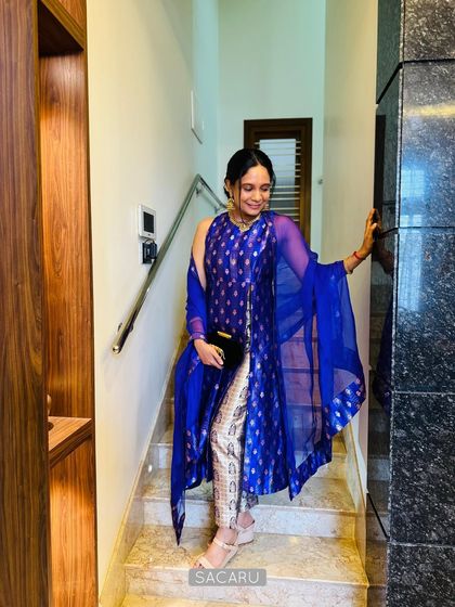 Pallavi descending a staircase, showcasing the beautiful flow and modern silhouette of her custom brocade kurta set.