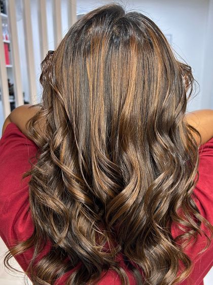 Stunning dimension and vibrant highlights. These perfectly styled waves showcase a beautiful blend of warm tones.