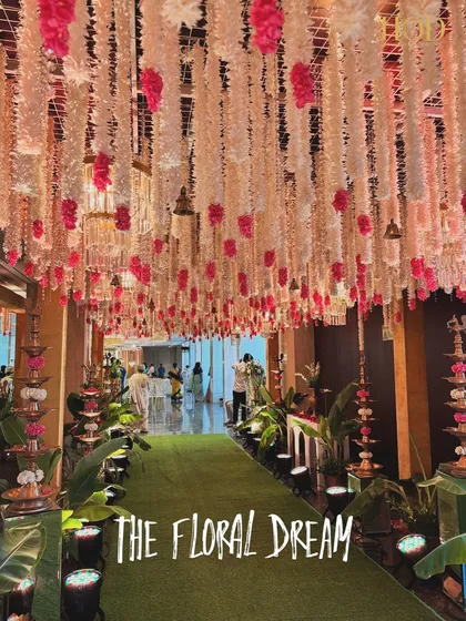 The full "Floral Dream" walkway, an immersive experience with a dense canopy of flowers and a lush green path for guests to walk on.