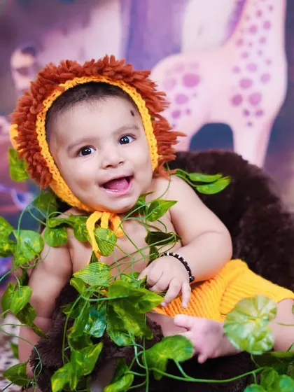 A happy, smiling baby lion, peeking through the leaves in our jungle studio.