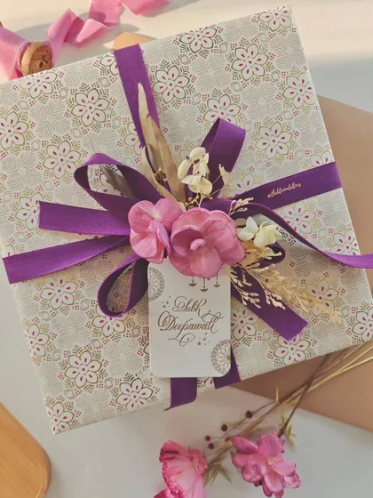 A beautifully wrapped gift containing hand-engraved glassware. The gift tag, featuring "Shubh Deepawali" in calligraphy, adds a festive and personal touch.