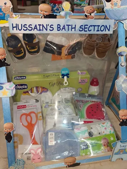 'Hussain's Bath Section', a practical hamper containing baby bath products, towels, nail clippers, and shoes.