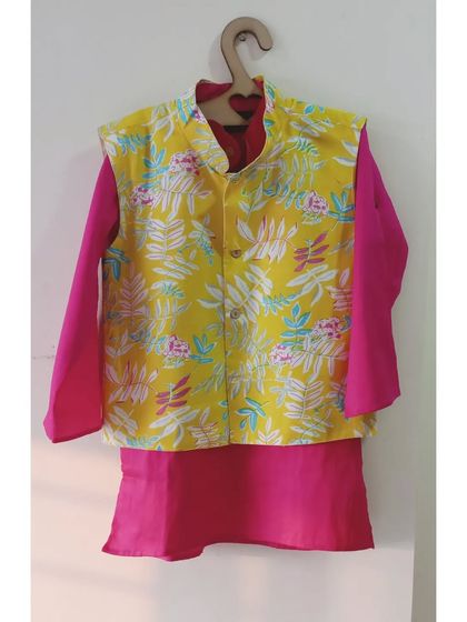This vibrant hot pink kurta is paired with a colorful floral jacket. The kurta is made of cotton silk and the jacket is lined cotton, making it a comfortable and eye-catching set.