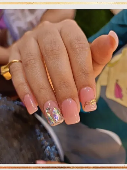 A lovely set of pink gel extensions with a single accent nail. The accent nail features a shattered glass effect with a delicate gold swirl on top for added texture and shine.
