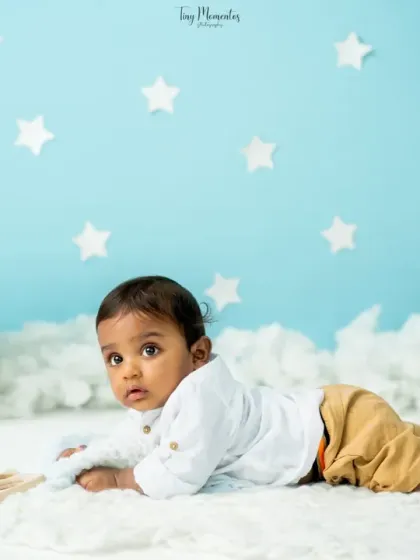 Tummy time on a soft cloud. This pose is perfect for younger babies, capturing their strength and adorable expressions in a whimsical setting.
