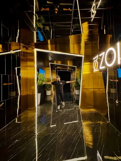 Posing in the futuristic, golden hallway of ZOI. Trusting the grind, riding the wave.