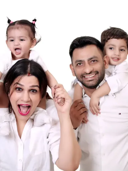 A fun and energetic family photo with children on their parents' shoulders.