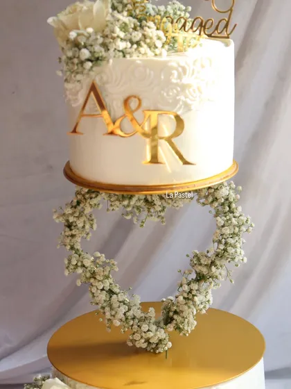 The heart-shaped floral garland is the star of this two-tier floating cake, creating a beautifully romantic silhouette.