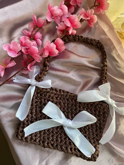 A product shot of my brown ribbon bag so you can see the details. I use a sturdy crochet stitch for the bag and strap, and add three big white satin bows for that kawaii touch.