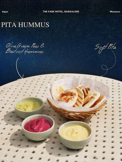 A trio of colorful hummus: olive, green peas, and beetroot, served with soft pita. A perfect small plate to share.