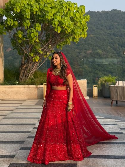 The dramatic flow of the red veil against the mountain backdrop in Dehradun. Her makeup remained flawless, a testament to the long-wearing products and techniques I use for destination weddings.