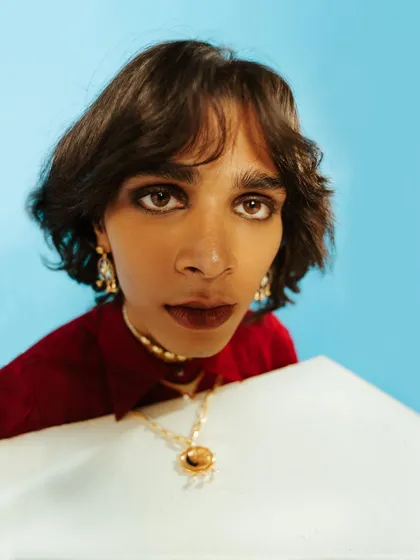 An extreme close-up portrait for an Amama Jewels campaign. This shot uses a wide lens to create a unique perspective, drawing full attention to the model's expression and the intricate jewelry.