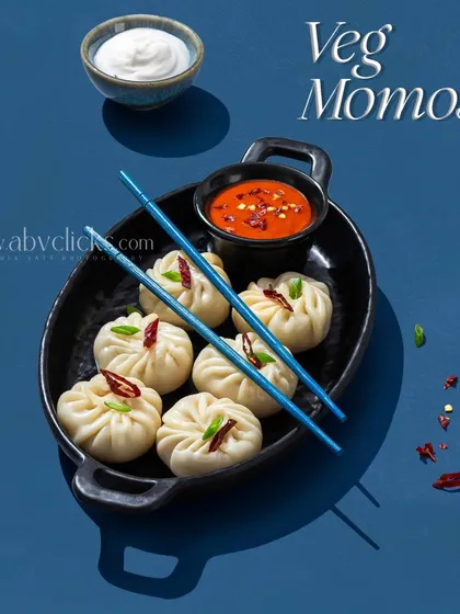A plate of steamed momos with a vibrant blue background, shot for a Pepsi campaign.