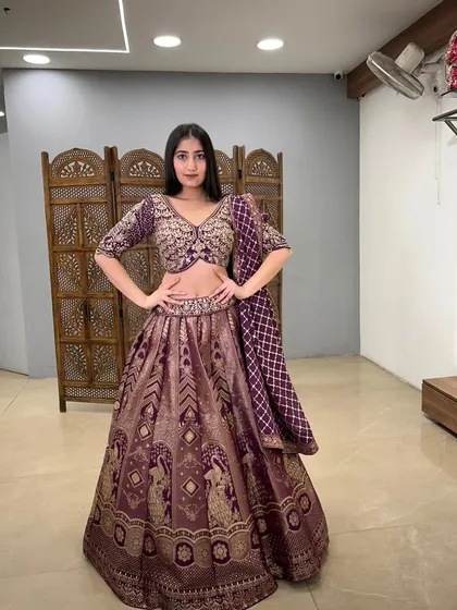 A confident pose in this beautiful purple lehenga, showcasing its intricate weaving and patterns.