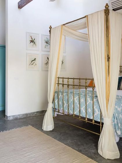 The interior of the Garden Suite, featuring a restored antique brass bed that serves as the centerpiece of the room. The design blends colonial charm with modern comfort.