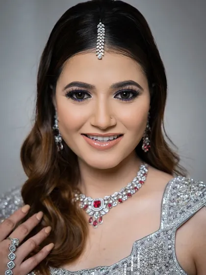 A happy and confident look for an evening celebration. This model wears a silver lehenga, beautifully accessorized with a ruby and zircon necklace and a delicate maang tikka.
