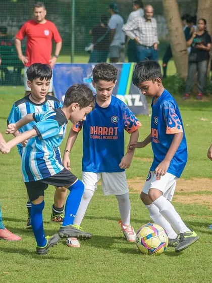 A group of our youngest players swarm around the ball, learning valuable lessons in teamwork and positioning in a fun, competitive environment.