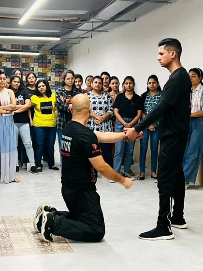 Demonstrating a technique from a kneeling position to show how to defend from a position of disadvantage.
