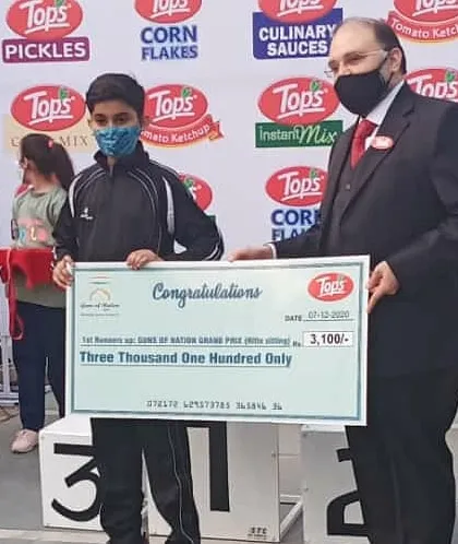 A student from our academy receiving his prize cheque at the Guns of Nation Grand Prix. These competitions provide valuable experience and recognition.