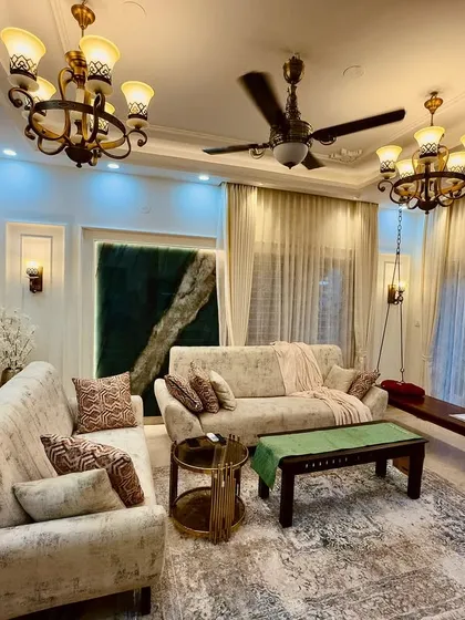 A full view of the living room from image 166, highlighting the plush sofas, classic chandeliers, and the harmonious blend of styles.