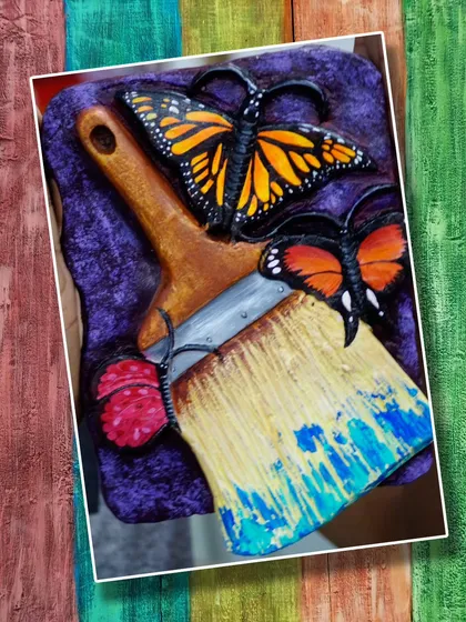 A creative relief artwork featuring a paintbrush and butterflies, symbolizing the transformative power of art. A wonderful concept executed beautifully by a student.