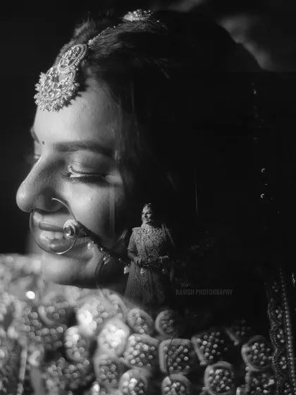 An artistic double exposure in black and white, blending a close-up of the bride's face with a full-length shot.