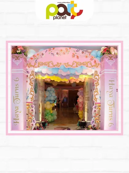 An ornate entrance arch for a Royal Ball, decorated with pastel balloons and personalized columns, setting a majestic tone for the celebration.