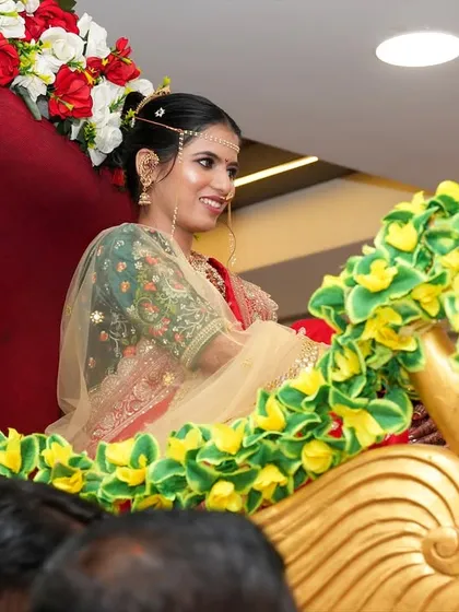 A side view of the bride in her doli, showing the elegant hairstyle and the perfect draping of her saree.