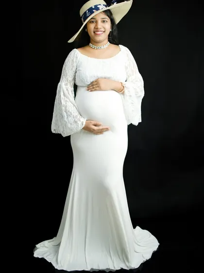 We can add simple props to personalize your solo session. Here, we added a stylish straw hat to complement the white lace gown, creating a chic and sophisticated maternity look.