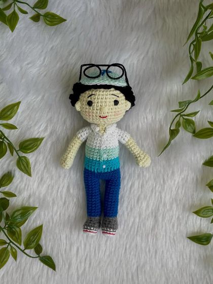 This handsome little boy replica doll features curly hair, a cap, and removable glasses. It’s so fun to create these little details that make each doll a true mini-me.