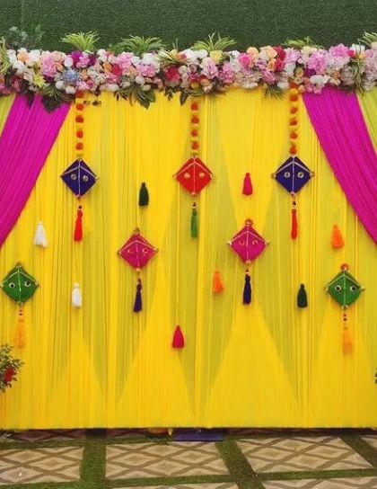 A simple and elegant Haldi backdrop with a floral border and kite-shaped tassels, perfect for a clean and modern look.