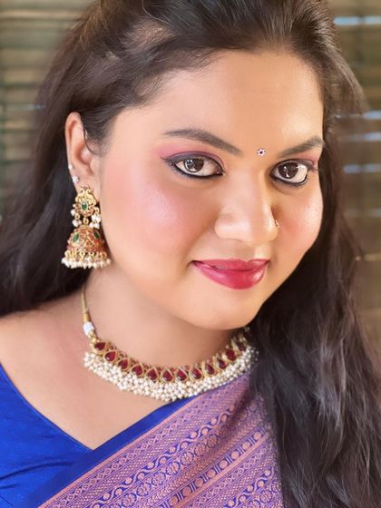 A close-up portrait of the guest, showing the details of the pink eyeshadow and red lipstick.